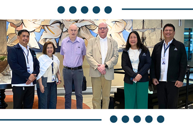Six professionals pose for a group photo in a bright lobby setting, smiling at the camera.