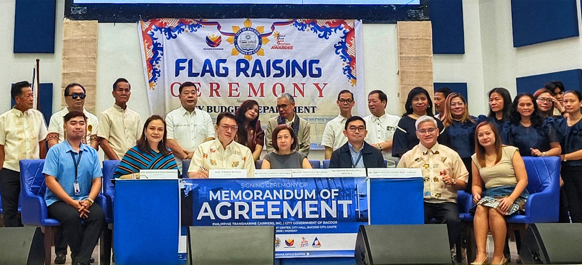 Group of officials and attendees posing on stage during a flag-raising ceremony and MOA signing.