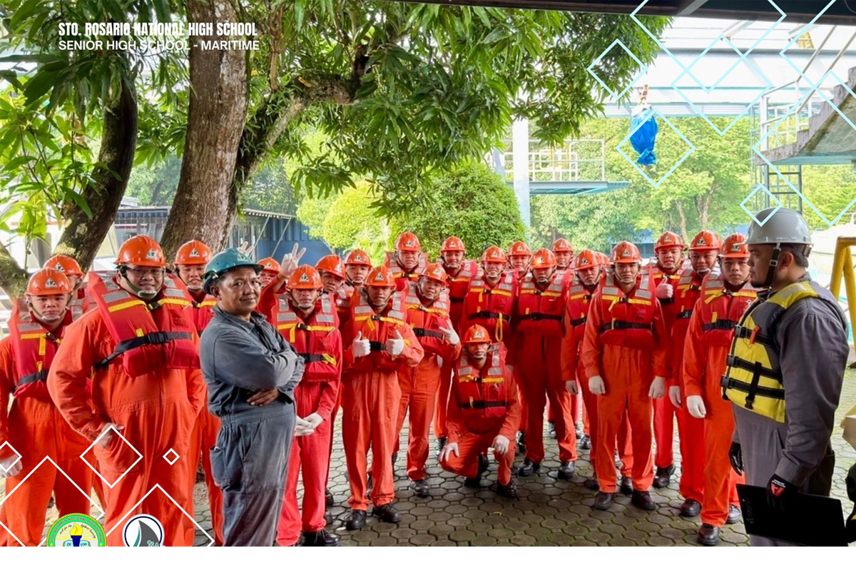 SRNHS students complete | PTC Group of maritime students in orange safety suits and helmets posing outdoors with two instructors in hard hats.
