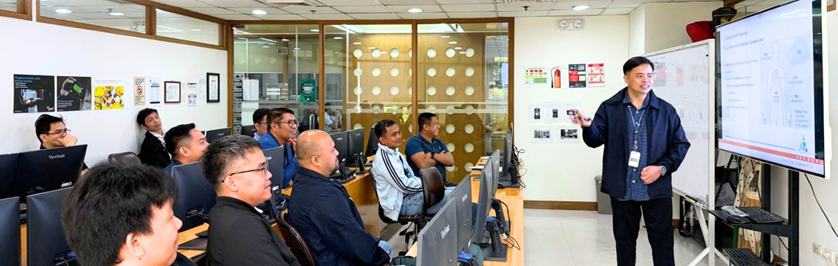PHILCAMSAT leads industry readiness-2 | PTC Instructor in a dark jacket presents to adults seated at computer workstations in a classroom, with a large screen on the right.