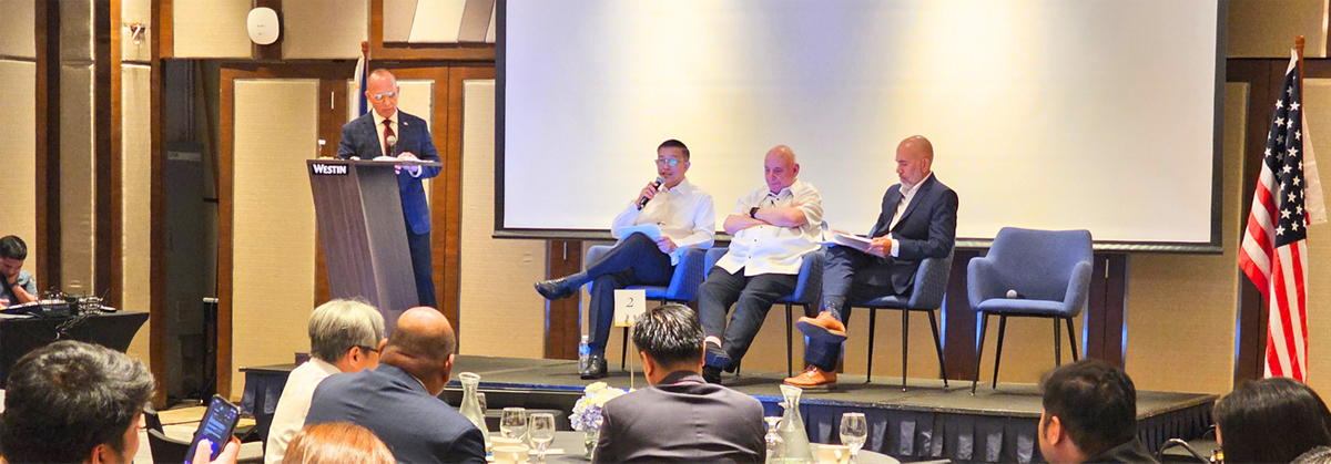 Padilla outlines Ph prospects-2 | PTC Speaker at a Westin podium addresses a panel of four men on stage, with a large screen behind them and an audience watching.