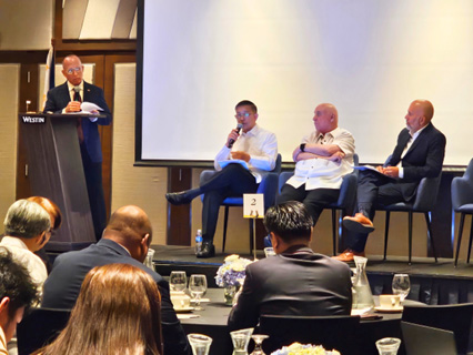 Padilla outlines Ph prospects-5 | PTC Moderator at lectern left, mic'd panelists seated on stage, audience watching a discussion in a conference room.