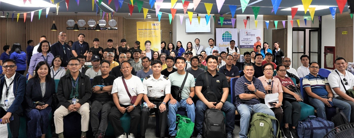Day of the Seafarer-2 | PTC Large group of people posing for a group photo at an indoor event, bunting overhead and banners in the background.