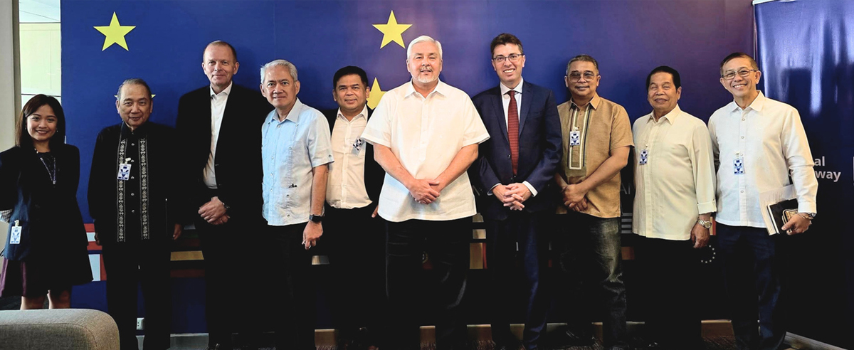 European Union Delegation-2 | PTC Group of ten professionals posing for a formal photo against a blue backdrop with yellow stars.
