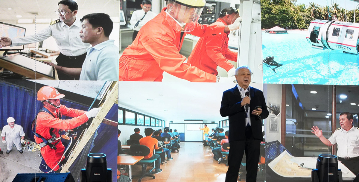 Seafarer Social Summit 2026-2 | PTC Speaker in a suit addresses an audience with a microphone, standing before a collage of workplace training scenes behind him.