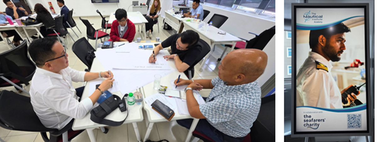 Group of adults around a table discussing and writing on large sheets in a bright classroom, with others at nearby tables in the background.