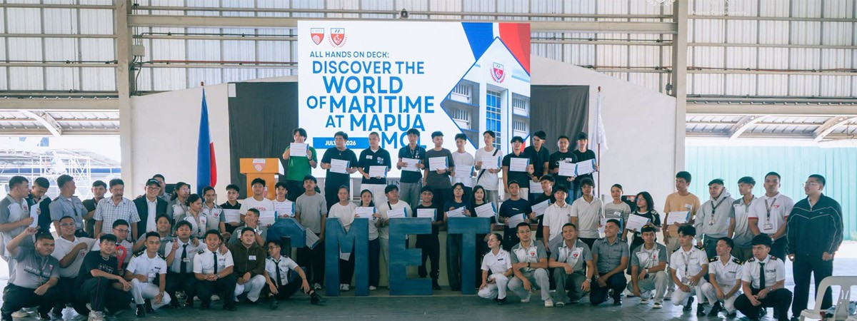 Mapúa-PTC CMET 02 | PTC Indoor group photo of students and instructors posing with certificates on a stage at a maritime event, backdrop reads 'Discover the World of Maritime at Mapua'