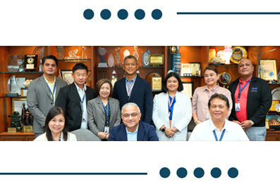 Group of ten professionals posing for a formal team photo in an office, with awards on shelves in the background.