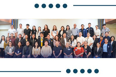 Group of diverse professionals posing for a large group photo at a conference or event.