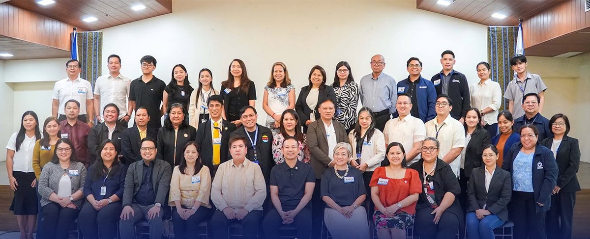 PTCs Karen Avelino champions 02 | PTC Group photo of about 40 professionals in a conference hall, wearing name badges and posing for a formal event portrait.