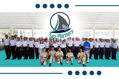 Group photo of the Sea Mariners team in white shirts posing together indoors with the circular Sea Mariners logo above them.